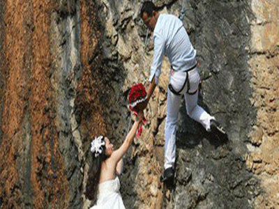 زوجان يتسلقان جبلاً لالتقاط أخطر صور زفاف في العالم